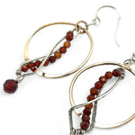 A pair of red garnet faceted gemstone earrings with sterling silver twists and bronze hoops