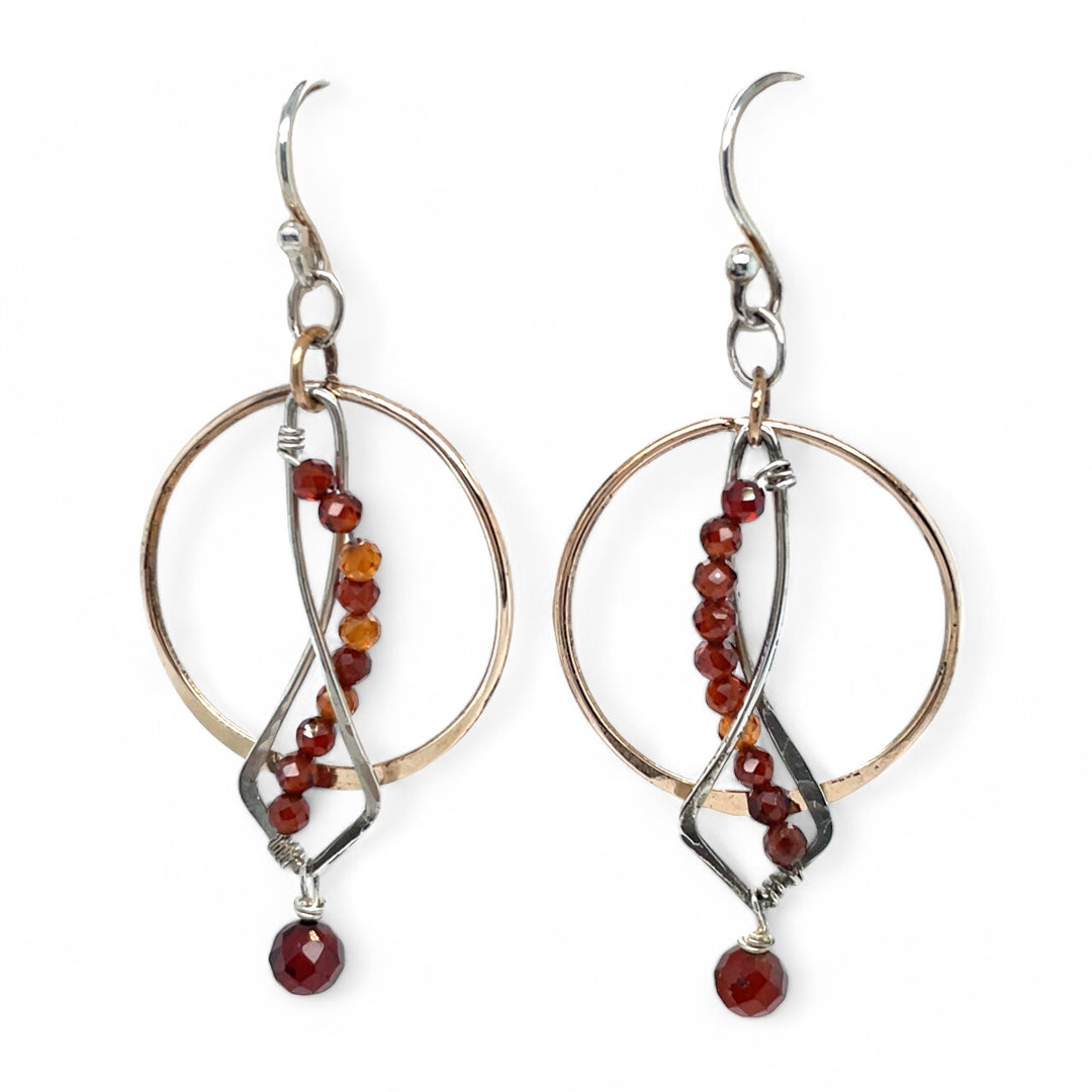 A pair of red garnet faceted gemstone earrings with sterling silver twists and bronze hoops