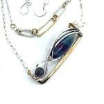 A double strand necklace with a geometric design, featuring fluorite and iolite faceted gemstones, hammered sterling silver, textured sterling silver links and handmade brass rings