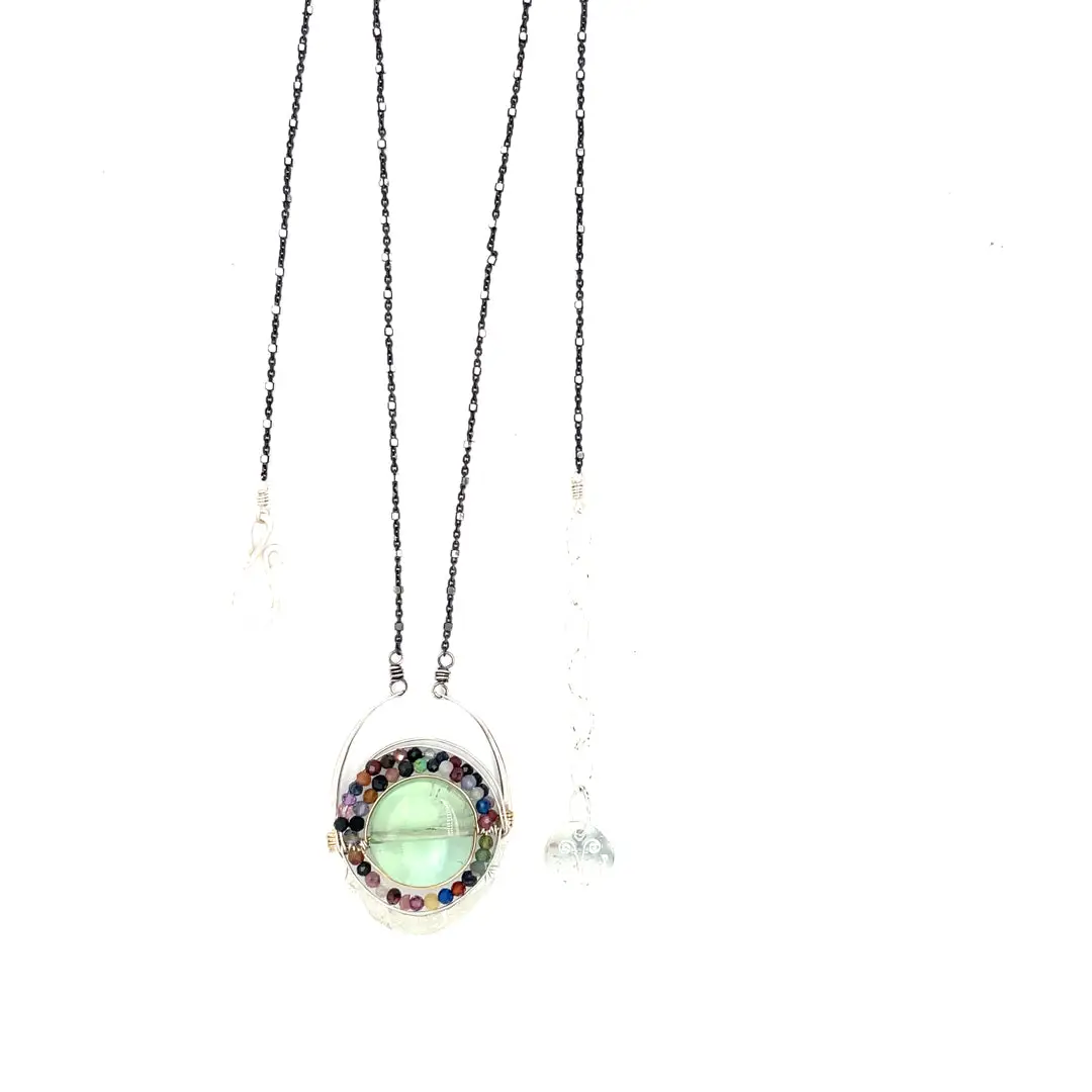 A sterling silver oval pendant necklace with a green fluorite smooth coin and micro faceted mixed gemstones, featuring an oxidized sterling silver dot chain 
