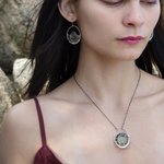 A sterling silver oval pendant necklace with a green fluorite smooth coin and micro faceted mixed gemstones, featuring an oxidized sterling silver dot chain 