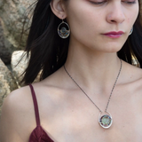 A sterling silver oval pendant necklace with a green fluorite smooth coin and micro faceted mixed gemstones, featuring an oxidized sterling silver dot chain 