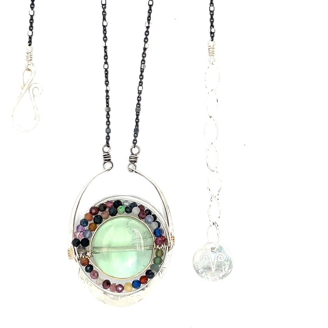 A sterling silver oval pendant necklace with a green fluorite smooth coin and micro faceted mixed gemstones, featuring an oxidized sterling silver dot chain 