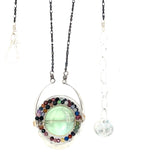 A sterling silver oval pendant necklace with a green fluorite smooth coin and micro faceted mixed gemstones, featuring an oxidized sterling silver dot chain 