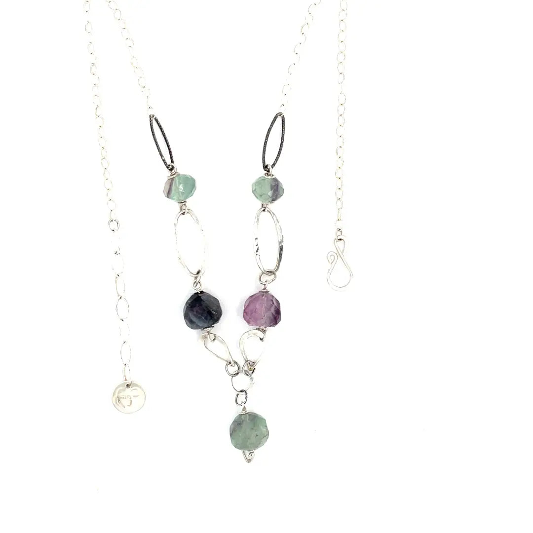 Purple and green faceted fluorite spheres are held within handmade hammered sterling silver oval and teardrop link, topped off with a delicate sterling silver chain necklace