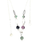 Purple and green faceted fluorite spheres are held within handmade hammered sterling silver oval and teardrop link, topped off with a delicate sterling silver chain necklace