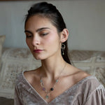 Purple and green faceted fluorite spheres are held within handmade hammered sterling silver oval and teardrop link, topped off with a delicate sterling silver chain necklace