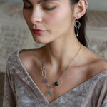 Purple and green faceted fluorite spheres are held within handmade hammered sterling silver oval and teardrop link, topped off with a delicate sterling silver chain necklace