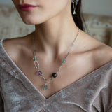 Purple and green faceted fluorite spheres are held within handmade hammered sterling silver oval and teardrop link, topped off with a delicate sterling silver chain necklace