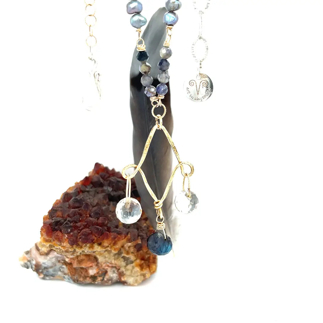  a brass chandelier necklace with a blue labradorite drop, gold-filled textured chain, with pearl and iolite gemstone embellishments.