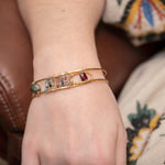 Brass skinny bracelet with flashy blue labradorite cube, garnet tile, green amethyst, and mixed gemstones on sterling silver wire