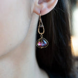 A pair of gold-filled wrapped fuchsia two-toned hematite crystal drop earrings with a hammered bronze mini drop and a crystal accent on gold filled earring hooks