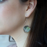 Iridescent abalone shell coins are surrounded by mauve moonstone gems within bronze teardrop earrings