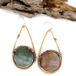 Iridescent abalone shell coins are surrounded by mauve moonstone gems within bronze teardrop earrings