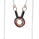 a bronze coil hammered pendant with garnet gemstones held from handmade hammered floral stamped oval links on sterling silver rolo chain necklace