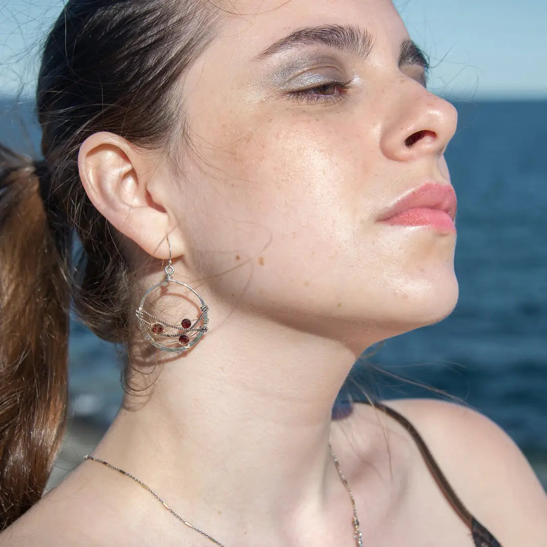 handmade sterling silver hoops with garnet faceted coins, gold-filled wire and darkened sterling silver twisted wire twisted within