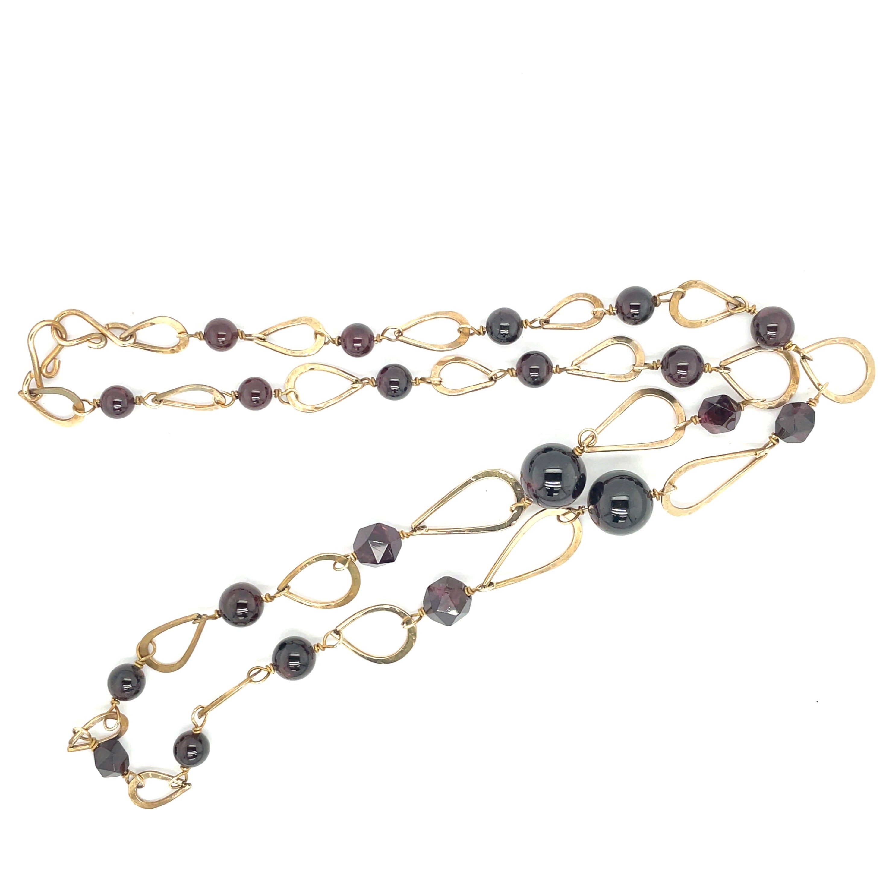 A brass long teardrop link chain necklace with smooth sphere garnet gemstones and faceted garnet gemstones