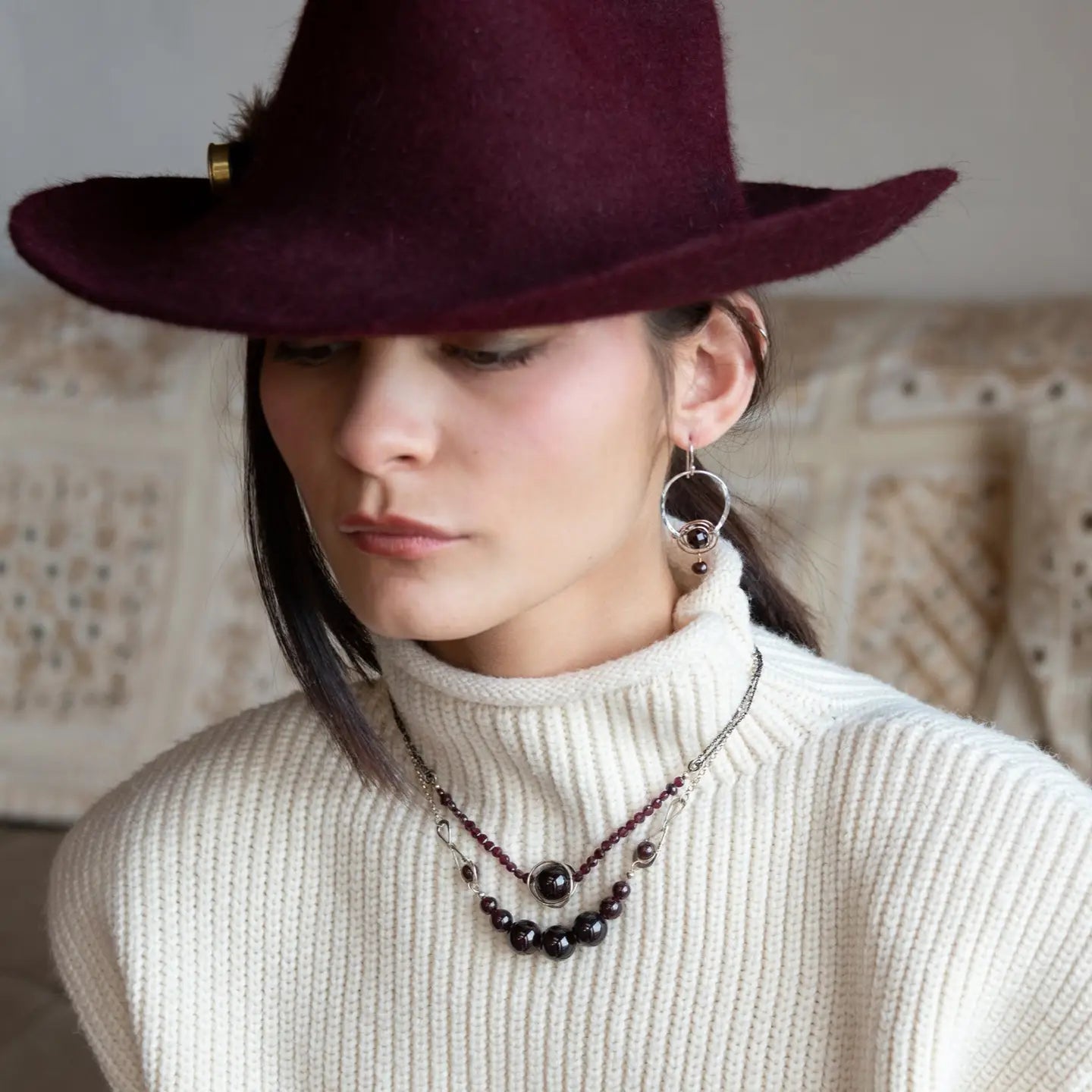 Sterling silver hammered hoops holding onto layers of bronze hammered wire wrapping a faceted garnet gemstone with a rich red fresh water pearl dangle earring