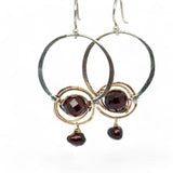 Sterling silver hammered hoops holding onto layers of bronze hammered wire wrapping a faceted garnet gemstone with a rich red fresh water pearl dangle earring
