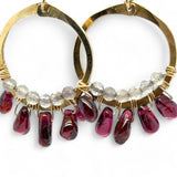 Smooth garnet drops line the bottom of a brass hammered hoop earring with the inside lined in faceted labradorite gemstones