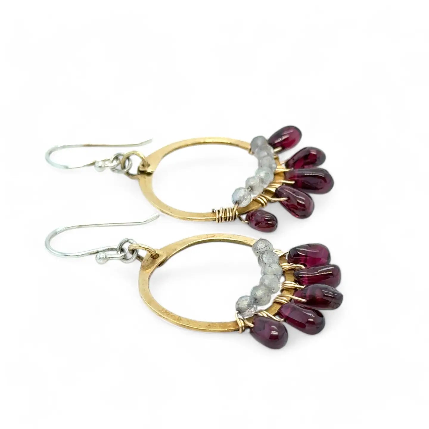 Smooth garnet drops line the bottom of a brass hammered hoop earring with the inside lined in faceted labradorite gemstones