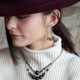 Smooth garnet drops line the bottom of a brass hammered hoop earring with the inside lined in faceted labradorite gemstones