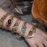 Amazonite, chrysocolla, blue quartz, and moonstone gemstones held within a handmade sterling silver wave shaped bracelet with oxidized twist, gold filled, and brass wire accents