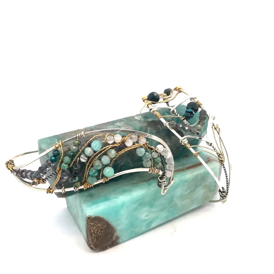 Amazonite, chrysocolla, blue quartz, and moonstone gemstones held within a handmade sterling silver wave shaped bracelet with oxidized twist, gold filled, and brass wire accents