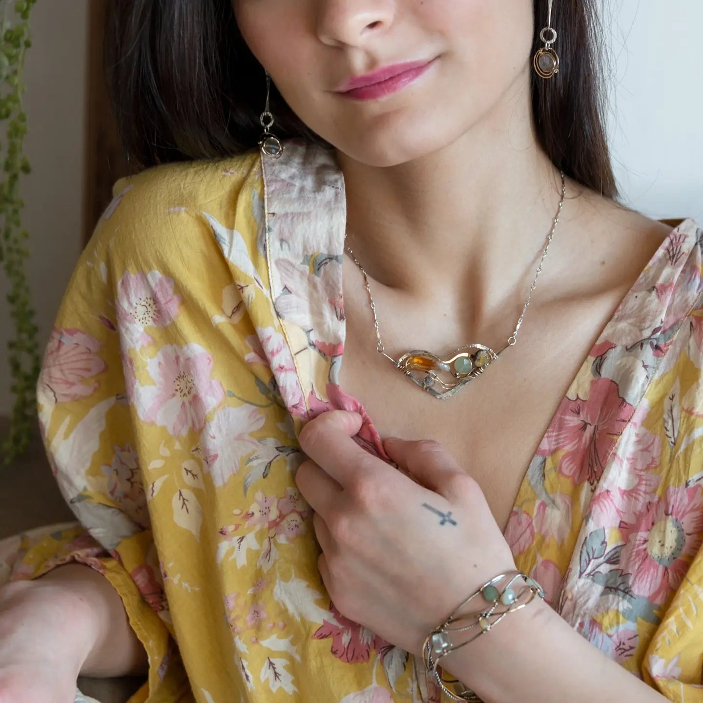 An oxidized sterling silver wedge pendant with waves of hammered sterling silver and brass wires, mixed with citrine, jade, crystal, and yellow opal gemstones to form this gemstone wedge necklace