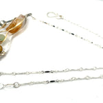 An oxidized sterling silver wedge pendant with waves of hammered sterling silver and brass wires, mixed with citrine, jade, crystal, and yellow opal gemstones to form this gemstone wedge necklace
