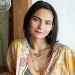 An oxidized sterling silver wedge pendant with waves of hammered sterling silver and brass wires, mixed with citrine, jade, crystal, and yellow opal gemstones to form this gemstone wedge necklace