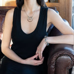 A collection of labradorite, purple blue fresh water pearl, green crystal, and quartz gemstones on a dandelion stamped oxidized sterling silver wide cuff bracelet