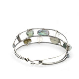A collection of labradorite, purple blue fresh water pearl, green crystal, and quartz gemstones on a dandelion stamped oxidized sterling silver wide cuff bracelet