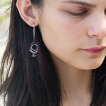 Darkened sterling silver ring surrounded by pink tourmaline and opal gemstones with a herkimer diamond dangle, attached to a darkened sterling silver twisted bar top earring