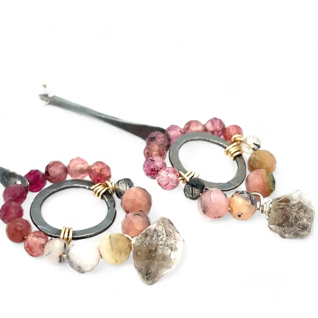 Darkened sterling silver ring surrounded by pink tourmaline and opal gemstones with a herkimer diamond dangle, attached to a darkened sterling silver twisted bar top earring