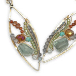 Green amethyst nuggets surrounded by labradorite, hessonite garnet, citrine, crystal, and amazonite gemstones wrapped in sterling silver and brass twist wires on a handmade hammered brass marquise earrings