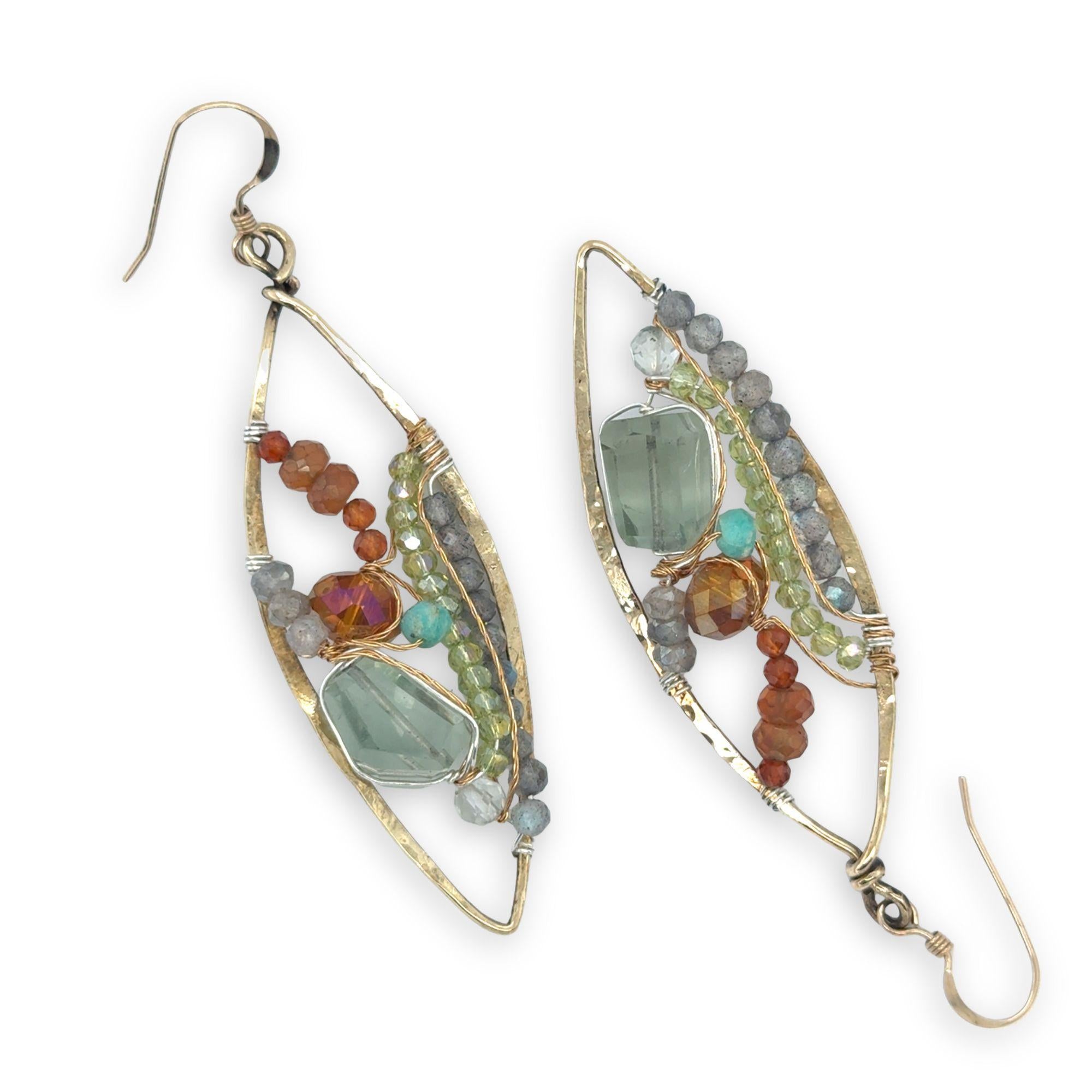 Green amethyst nuggets surrounded by labradorite, hessonite garnet, citrine, crystal, and amazonite gemstones wrapped in sterling silver and brass twist wires on a handmade hammered brass marquise earrings