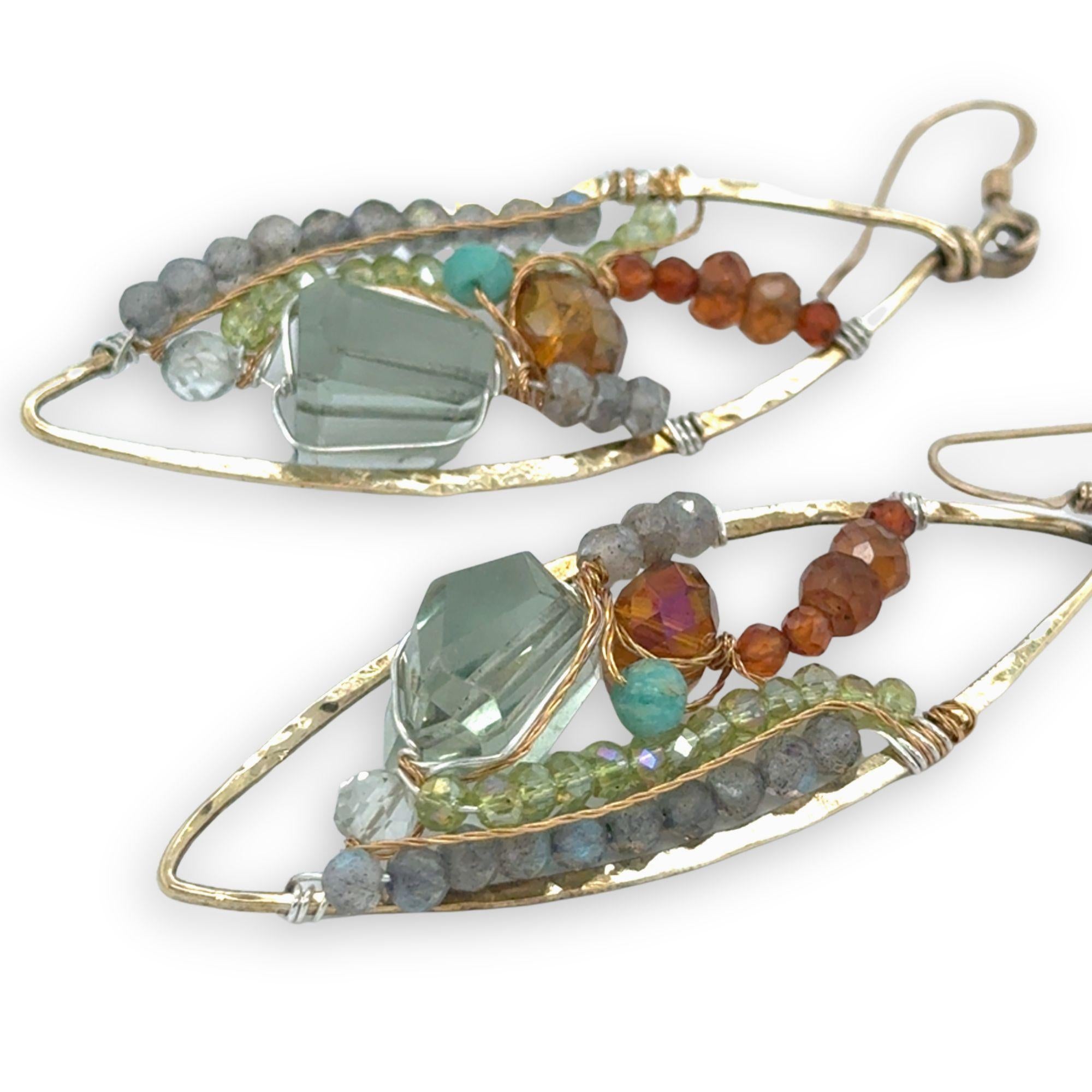 Green amethyst nuggets surrounded by labradorite, hessonite garnet, citrine, crystal, and amazonite gemstones wrapped in sterling silver and brass twist wires on a handmade hammered brass marquise earrings