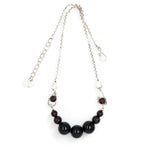 Smooth garnet sphere gemstones are suspended between handmade sterling silver hammered teardrops on sterling rolo chain necklace