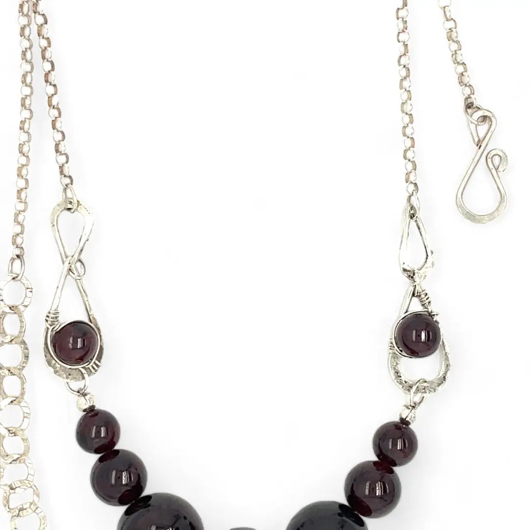 Smooth garnet sphere gemstones are suspended between handmade sterling silver hammered teardrops on sterling rolo chain necklace