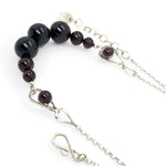 Smooth garnet sphere gemstones are suspended between handmade sterling silver hammered teardrops on sterling rolo chain necklace