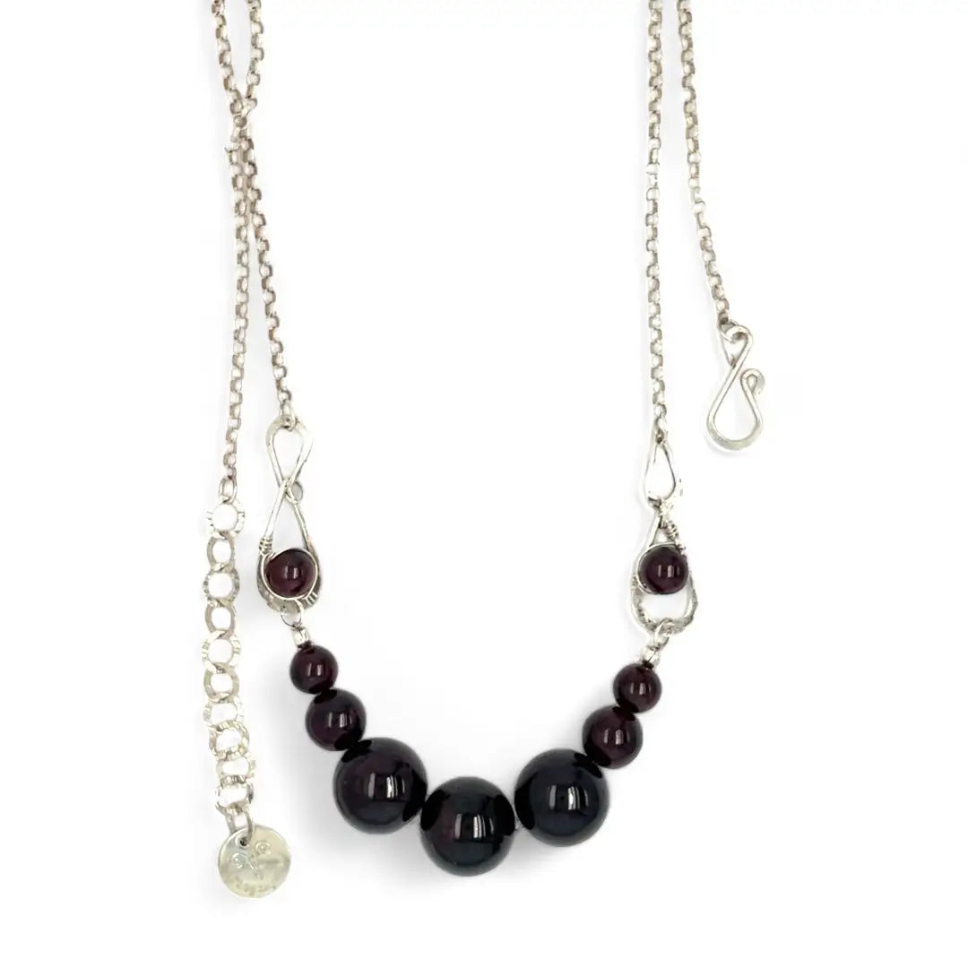 Smooth garnet sphere gemstones are suspended between handmade sterling silver hammered teardrops on sterling rolo chain necklace