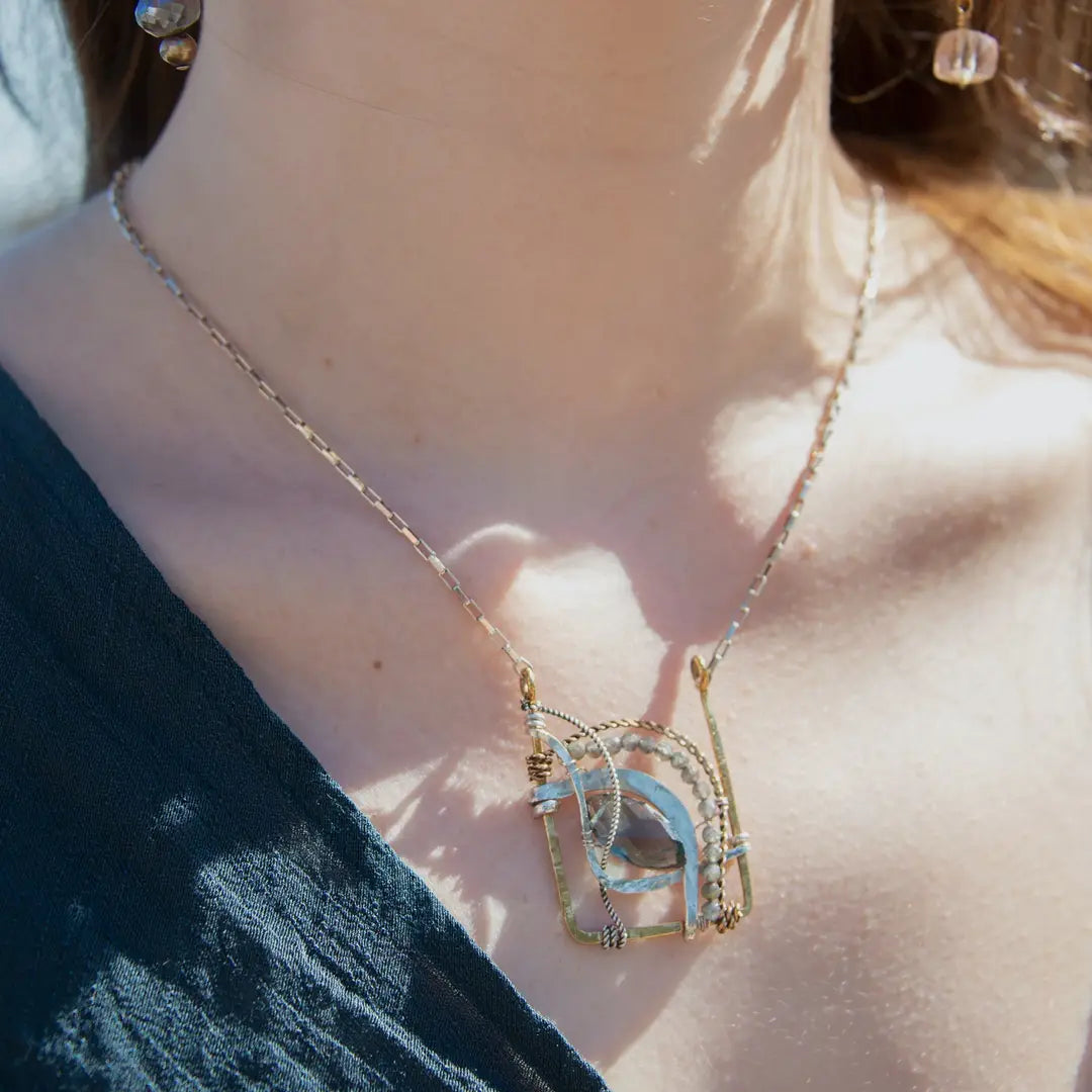 London blue quartz, pyrite, bloodstone, and blue tourmaline gemstones sit within a brass box pendant with sterling silver and gold filled wire accents on a sterling silver box chain