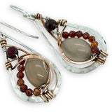 Small sterling silver hammered drop earrings embellished with glowing smooth moonstone oval wrapped in bronze wire and faceted hessonite gemstones