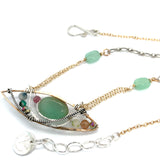 An eye shaped hammered bronze pendant with chrysoprase, tourmaline, crystal, and jade gemstones on delicate double gold filled chain attached to jade faceted gemstones on textured oxidized sterling silver chain necklace