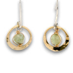 Tiny hammered brass hoops with green kyanite gemstones in center wrapped in 14k gold filled wire, hanging from handmade sterling silver long hook earrings