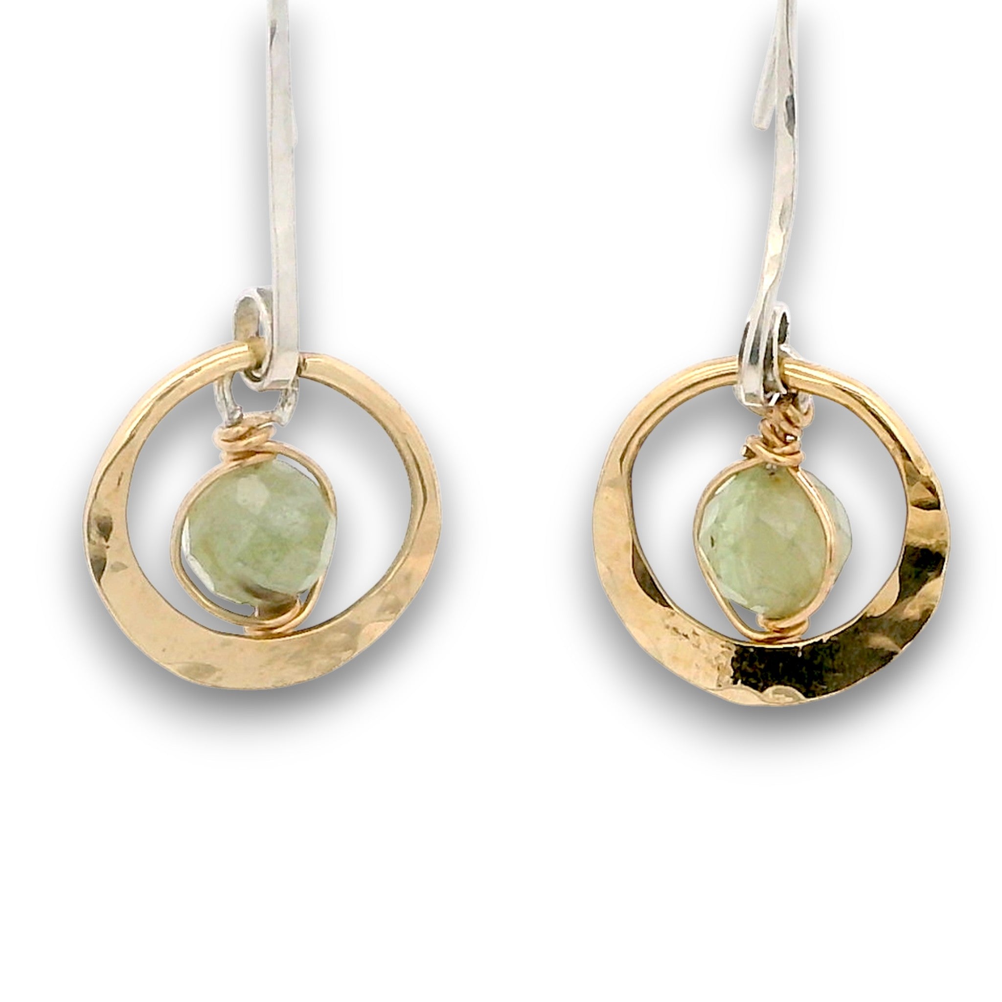 Tiny hammered brass hoops with green kyanite gemstones in center wrapped in 14k gold filled wire, hanging from handmade sterling silver long hook earrings