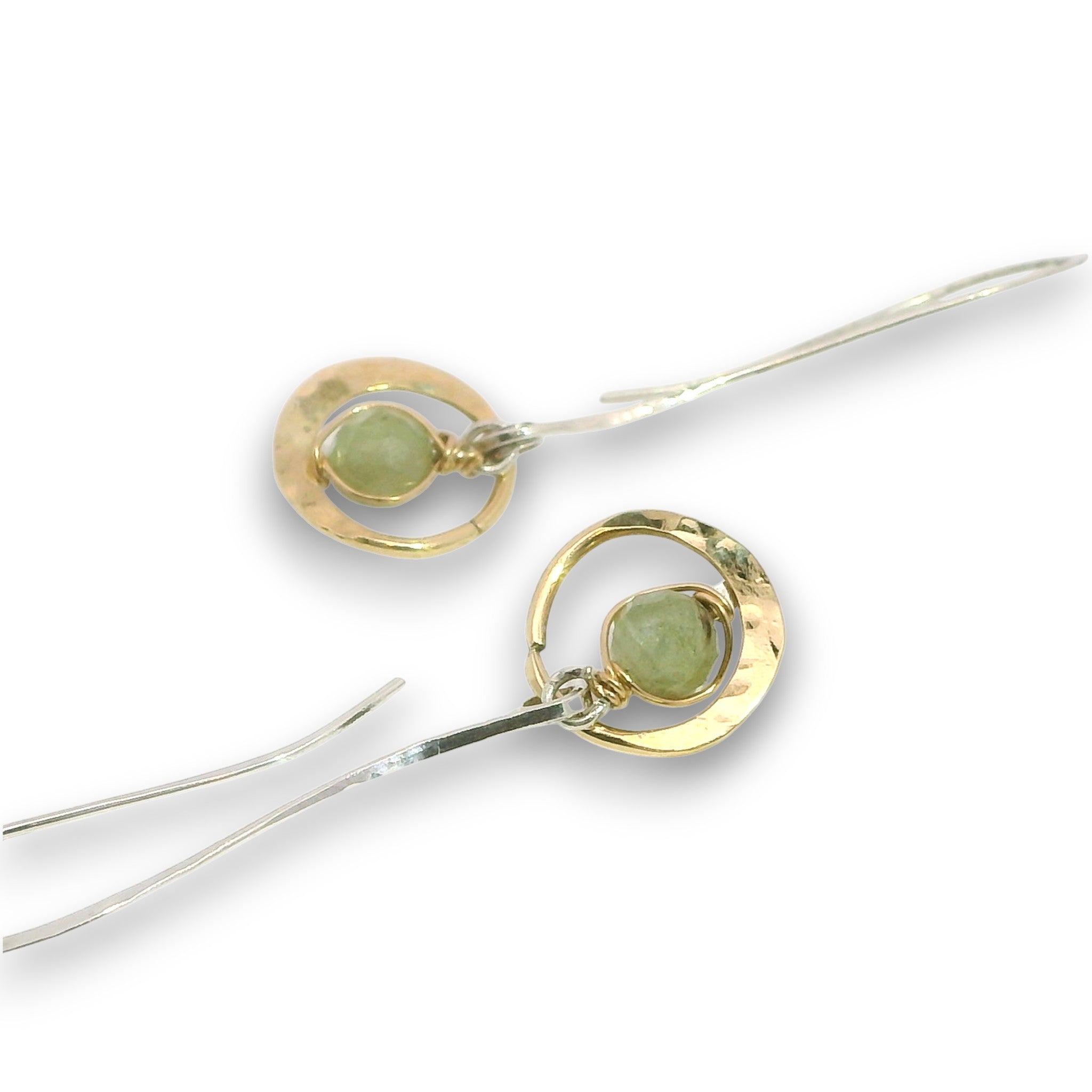 Tiny hammered brass hoops with green kyanite gemstones in center wrapped in 14k gold filled wire, hanging from handmade sterling silver long hook earrings
