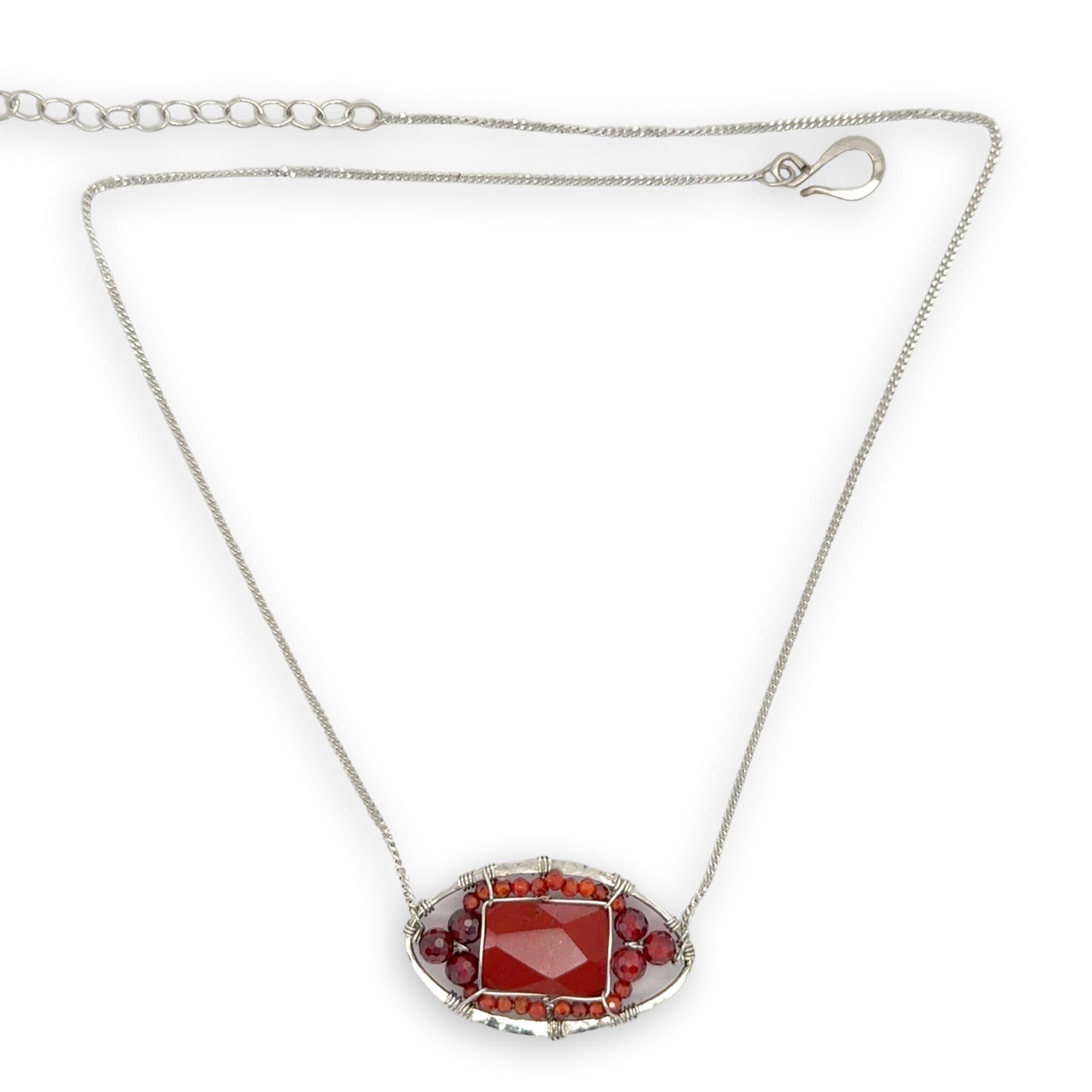 Red jasper tile surrounded by red and orange cubic zirconia gemstones in a hammered sterling silver pendant necklace