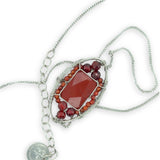 Red jasper tile surrounded by red and orange cubic zirconia gemstones in a hammered sterling silver pendant necklace